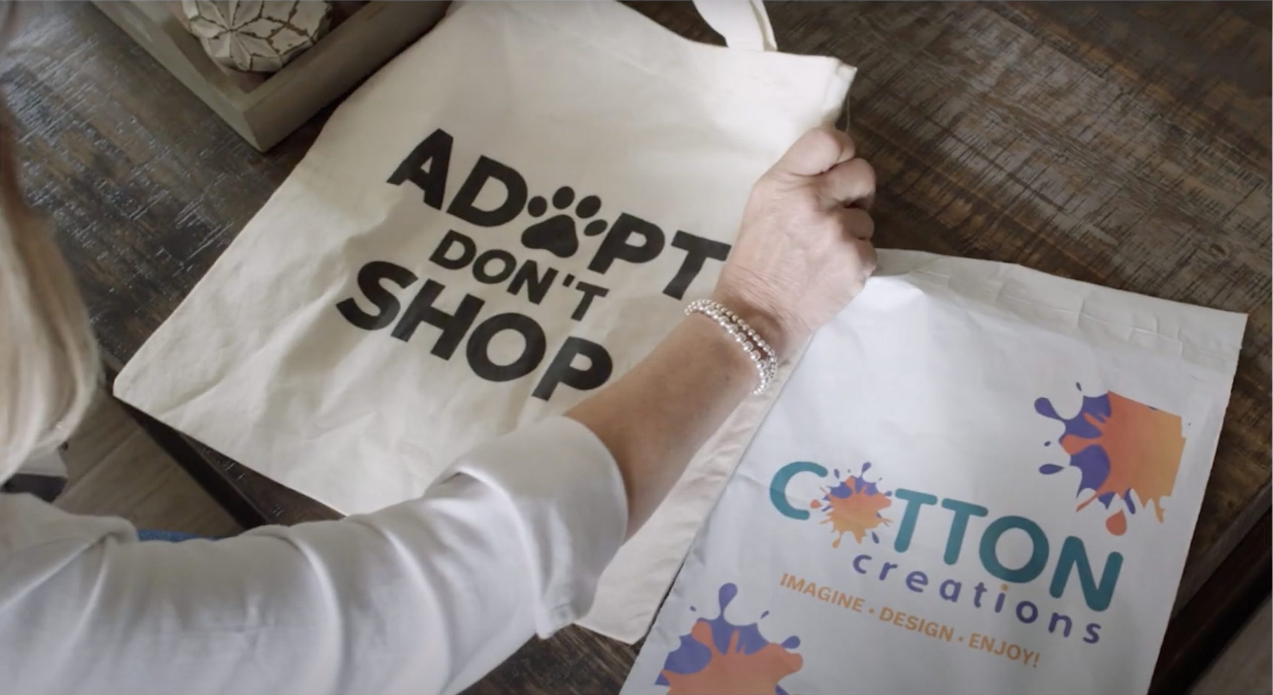 A custom printed tote bag that says "Adopt don't shop"