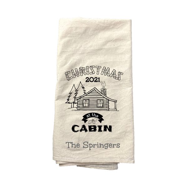 A customized tea towel that says "Christmas at the Cabin"