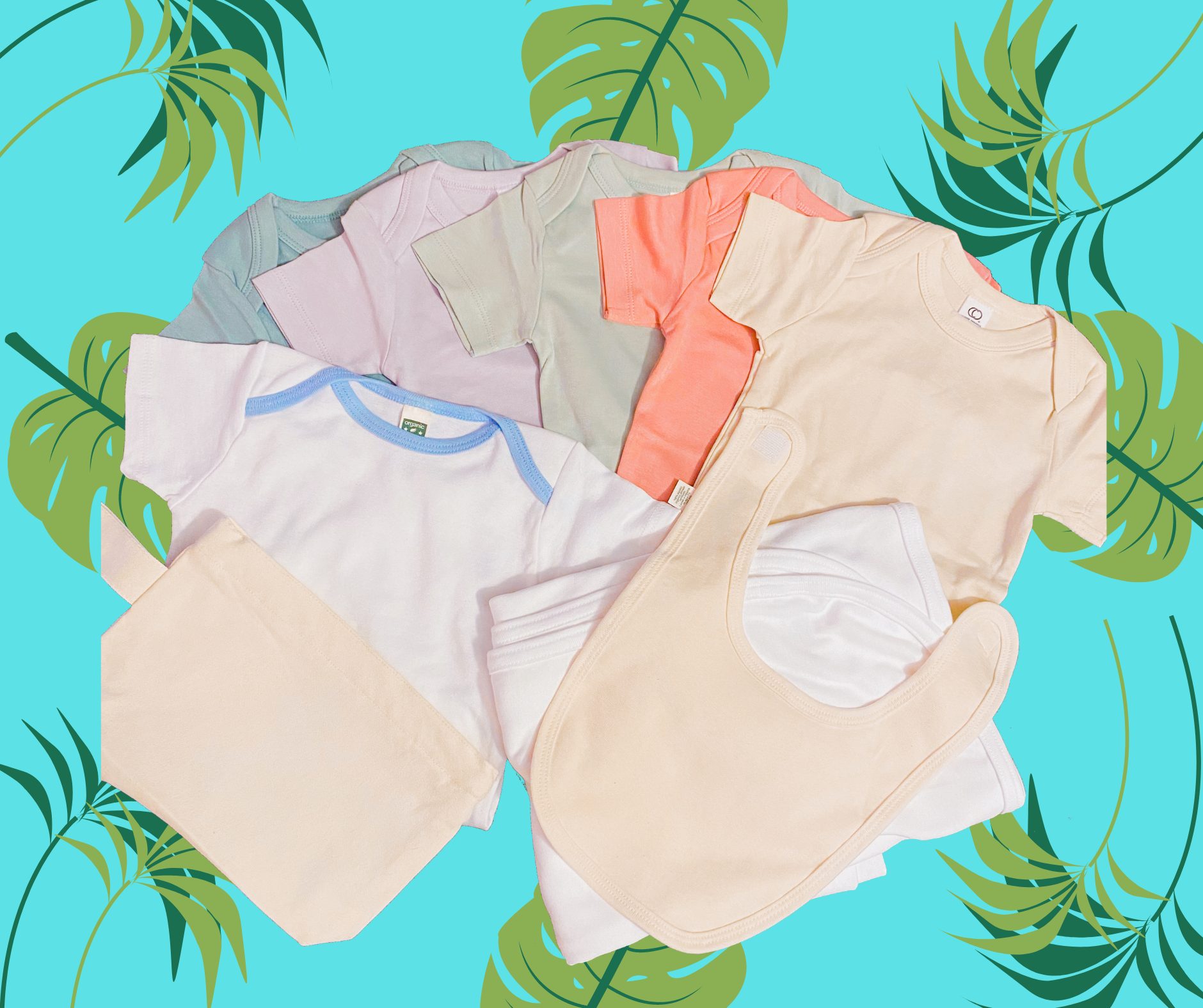 A variety of blank onesies, bibs and burp cloths